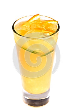 Orange juice with ice and fruit pieces in a glass on an isolated white background