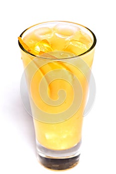 Orange juice with ice and orange pieces in a glass on an isolated white background