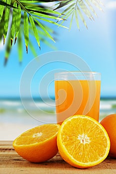 Orange juice with oranges and blur beach background.