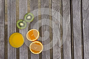 Orange juice, oranges and kiwis on a table