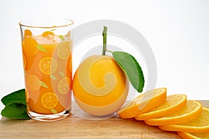 Orange juice and oranges with leaves