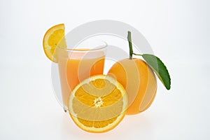 Orange juice and oranges with leaves