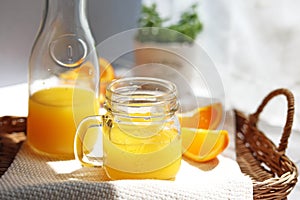 Orange juice poured into a mason jar mug cup