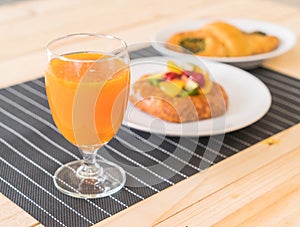 orange juice with spinach croissant and mixed fruits danish