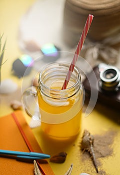 Orange Juice Between Summer Beach Accessories on Yellow Background