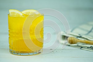 Orange juice in transparent glass with lemonade sliced lemon