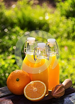 Orange juice and wooden mudler. Orange drink in bottles