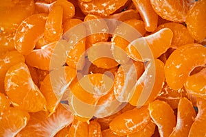 Orange juicy tangerine slices as a textured background. Flat lay. Fresh summer vitamin rich fruits. Macro shot