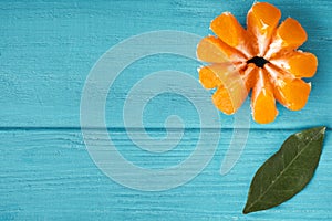 Orange juicy tangerine slices on the wooden turquoise background. Flat lay. Copy space. Fresh summer vitamin rich fruits
