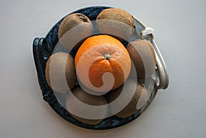 Orange and kiwis on a decorative blue platter.