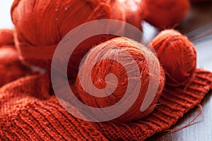 Orange knitwork with thread balls in a basket