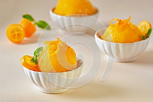 Orange kumquat ice cream sorbet in bowl. Closeup