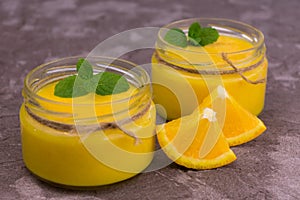 Orange Kurd in low jars. Orange summer, refreshing dessert. Close-up. photo