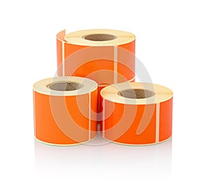 Orange label roll isolated on white background with shadow reflection. Color reel of labels for printers.