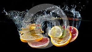 Orange, lemon, grapefruit and lime splashing into water