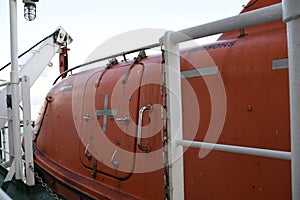 Orange life boat secured on the ship side of the vessel