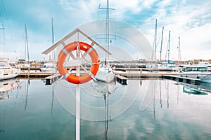 Orange life buoy on the pier by the sea