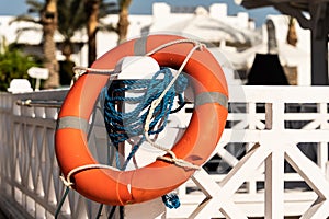 orange life buoy, safety near swimming pool, lifesaver, blue ropes