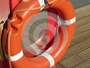 Orange life buoy on wooden pier in the harbor