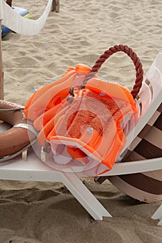 Orange life jackets and lifebuoy on a sand background. Beach lifeguard concept