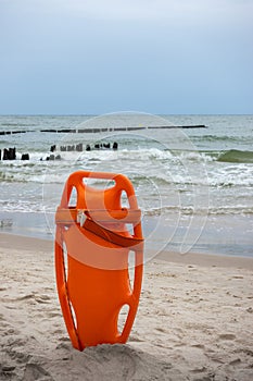 An orange lifeboat stuck in the sand on the beach.