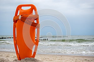 An orange lifeboat stuck in the sand on the beach.