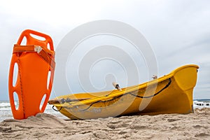 An orange lifeboat stuck in the sand on the beach.