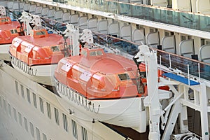 orange Lifeboats hanging over deck on cruise ship