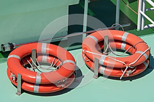 Orange lifebuoy at the boat, lifeguard float. Lifeguard equipment, life saver or life ring. Concept of vacation and safety when