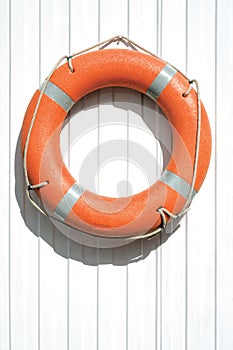 Orange lifebuoy on fence.