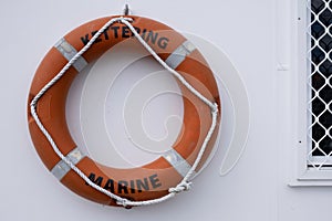 Orange lifebuoy hanging on a wall