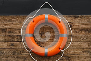 Orange lifebuoy hanging on wall. Rescue equipment