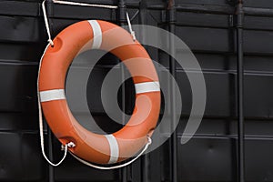 Orange lifebuoy hanging on the wall