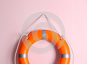 Orange lifebuoy on pink background. Rescue equipment