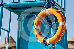 Orange Lifebuoy with Ropes on Lifeguard Chair