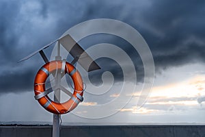 Orange lifebuoy on a stand on harbor pier