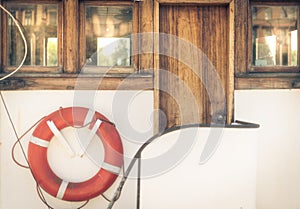 Orange lifebuoy on vintage white boat in port