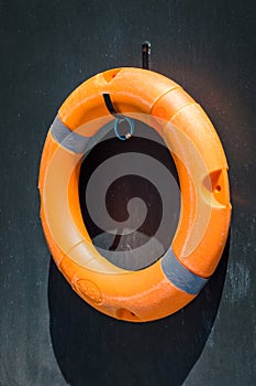 Orange lifebuoy on the wall near swimming pool