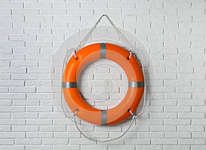 Orange lifebuoy on white brick wall. Rescue equipment