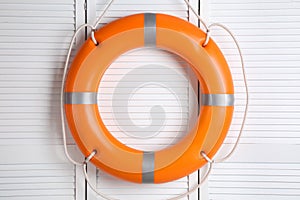 Orange lifebuoy on white wooden background. Rescue equipment