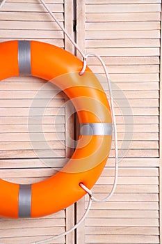Orange lifebuoy on wooden background. Rescue equipment