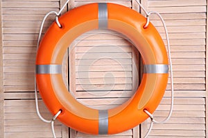 Orange lifebuoy on wooden background. Rescue equipment