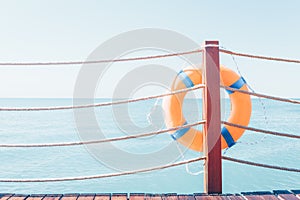 Orange Lifebuoy on the wooden column of the pier