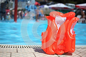 Orange lifejacket near pool in aquapark