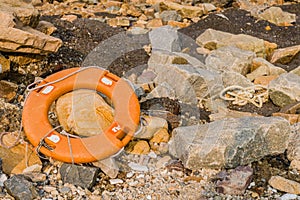 Orange lifesaver discarded on beach