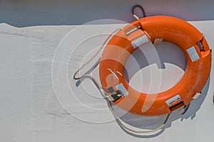 Orange lifesaver ring hanging on boat