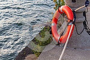 Orange Lifesaver Tied Up by the Water