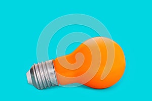 Orange light bulb isolated on blue background