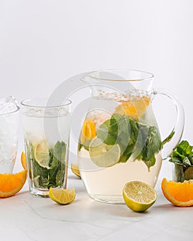 Orange and lime lemonade in a jug and glass