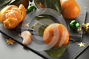Orange mandarin fruits on the black slate plate background
